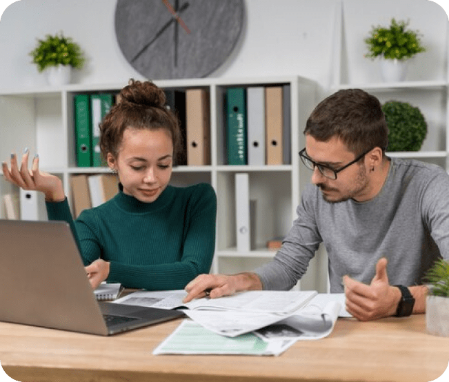 Two people working together at a desk.