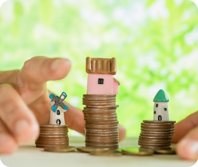 Coin stacks with miniature houses and windmill.