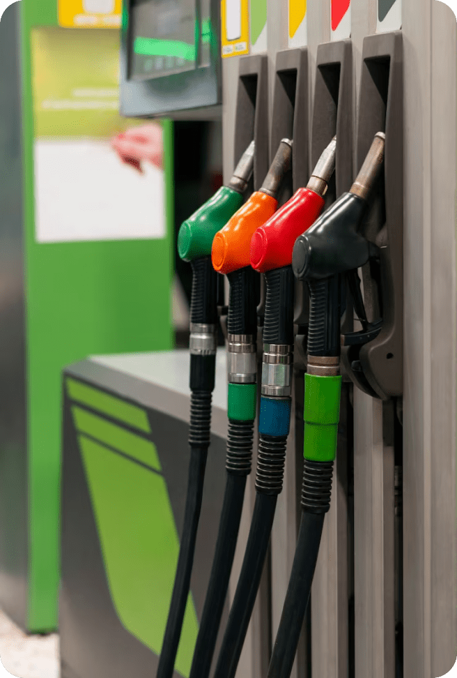 Four colorful gas pump nozzles at station.