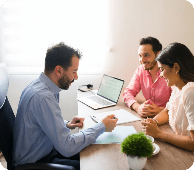 Couple signing documents with advisor.