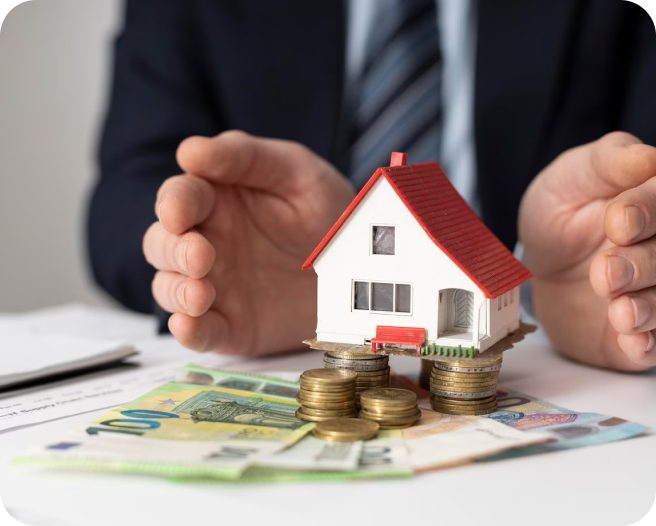 Man's hands protecting house model on money.