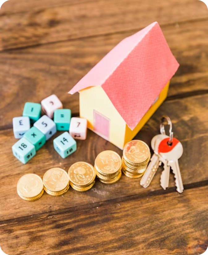 House, keys, coins, and dice on wood.