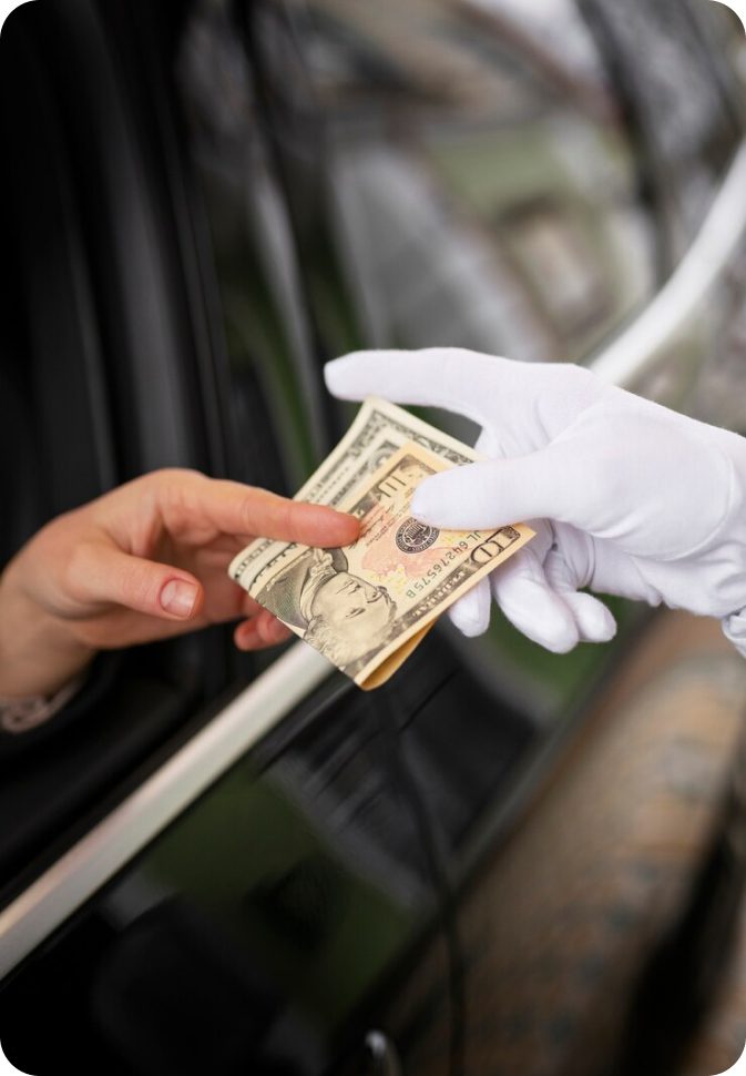 Handing money to someone in a car.